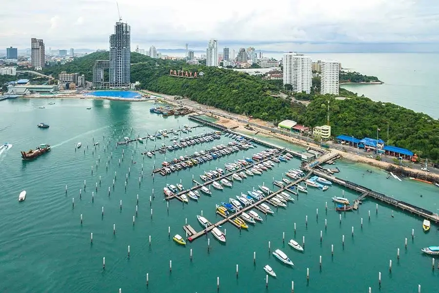 Dynamic coastal cityscape of Pattaya with high-rise buildings, beach promenade and busy waterfront activities